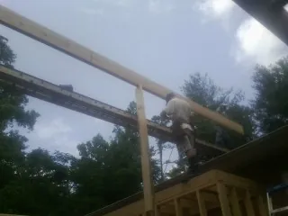Carpenter setting a ridge beam over a new addition frame — Ice Dam Removal by Roofing Brothers in Knoxville